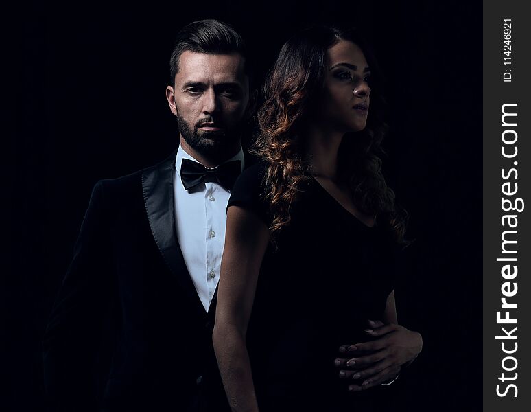 Elegant Man And Woman Posing Next To Each Other On Studio.