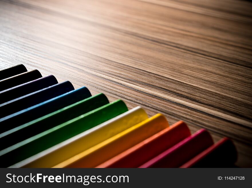 Colorful rainbow pencils on the brown table backgrounds