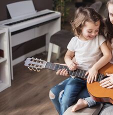 Mother And Daughter Playing A Guitar Stock Photos