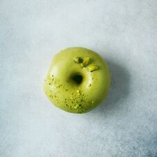 Sweet Doughnut With Green Glaze And Pistachio On Grey Background. Tasty Donut On Pastel Concrete Texture, Copy Space Stock Photo