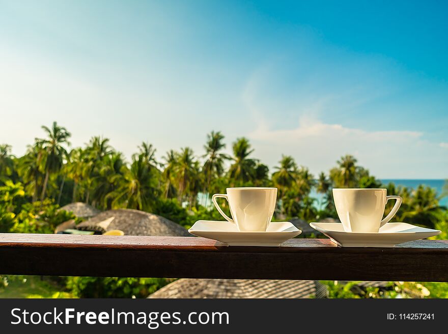 White coffee cup with beautiful paradise island sea and beach