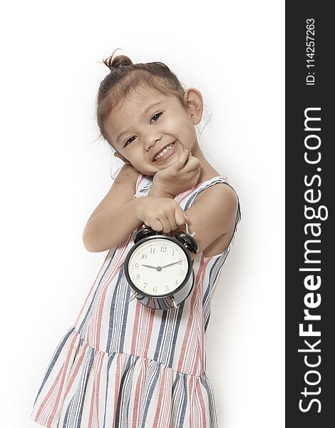 asian baby kid girl playing black alarm clock on gray background. asian baby kid girl playing black alarm clock on gray background