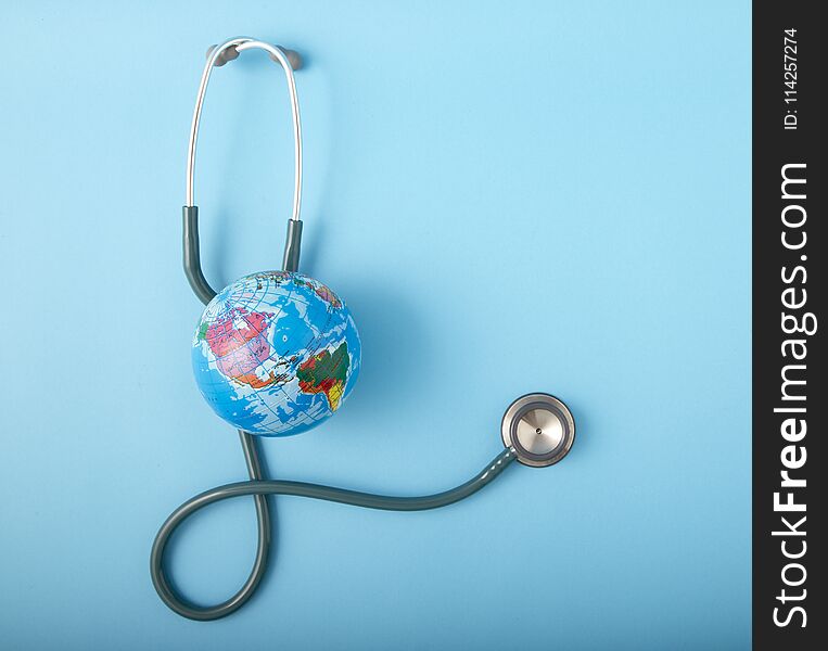 World health day ,Stethoscope wrapped around globe on pastel blue background. Save the wold, Global health care and Green Earth day concept. World health day ,Stethoscope wrapped around globe on pastel blue background. Save the wold, Global health care and Green Earth day concept