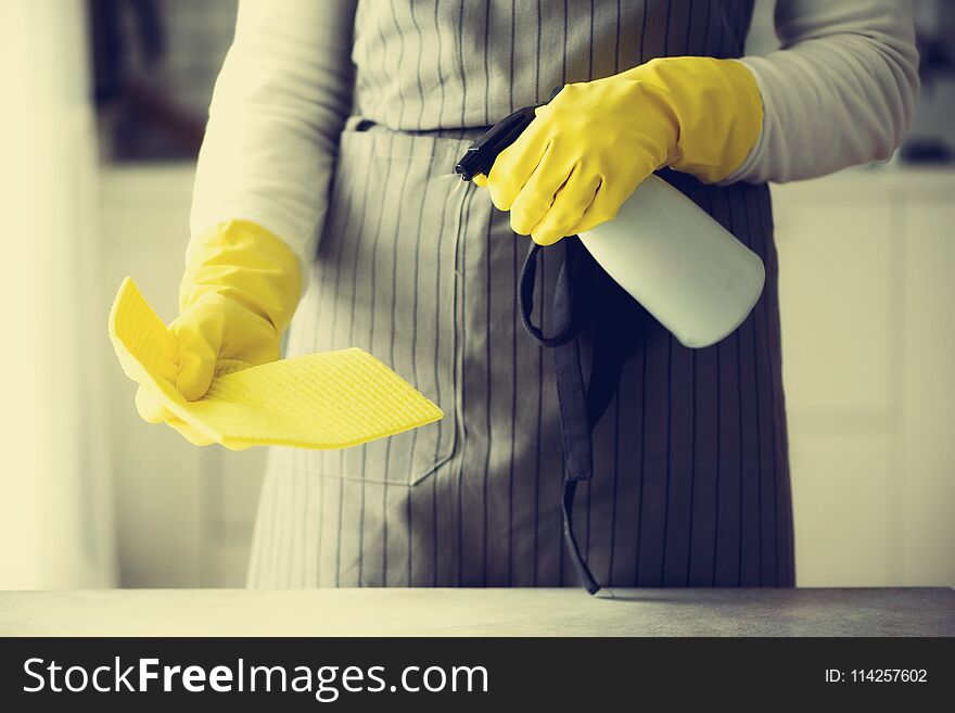 Woman in yellow rubber protective gloves wiping dust and dirty. Cleaning concept, banner, copy space.