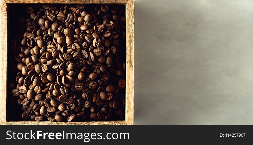 Raw and roasted coffee beans in wooden box. Ingredients for coffee beverage. Food background. Banner.