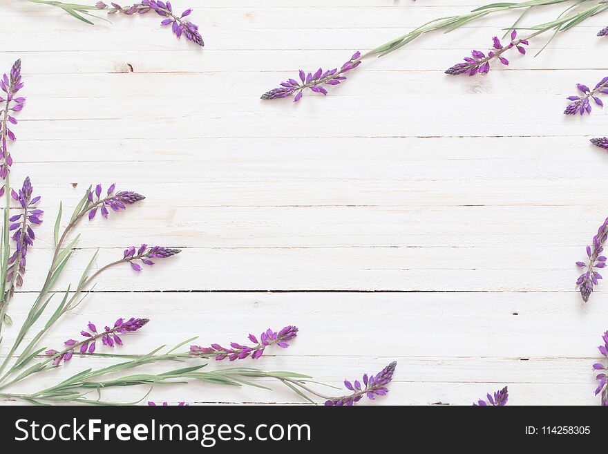 The violet flowers on white wooden background