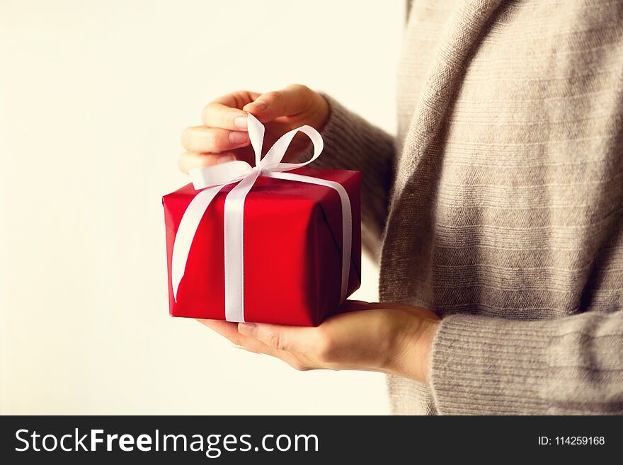 Female hands opening red gift box, copy space. Christmas, new year, birthday party, valentine`s day, mother`s and woman