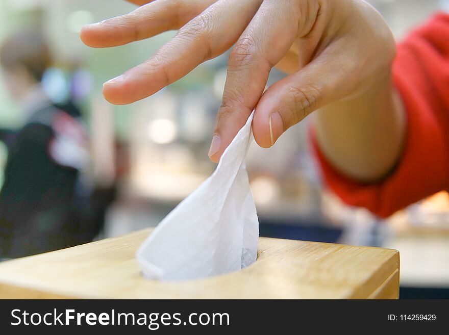 Women hand picking napkin/tissue paper from the tissue box