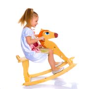 Girl Swinging On A Wooden Horse. Stock Photography