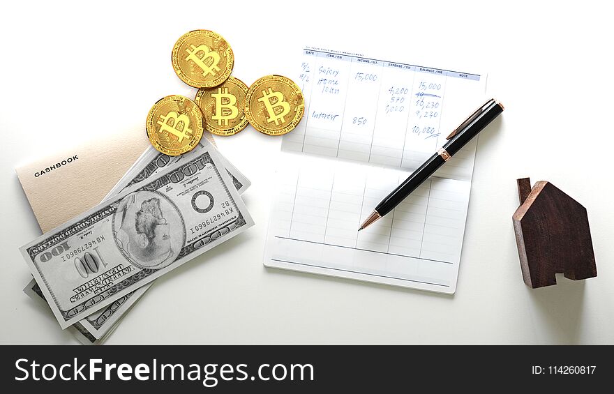 Four golden bitcoin coins, digital crypto currency, next to to a personal list of expenses and spendings