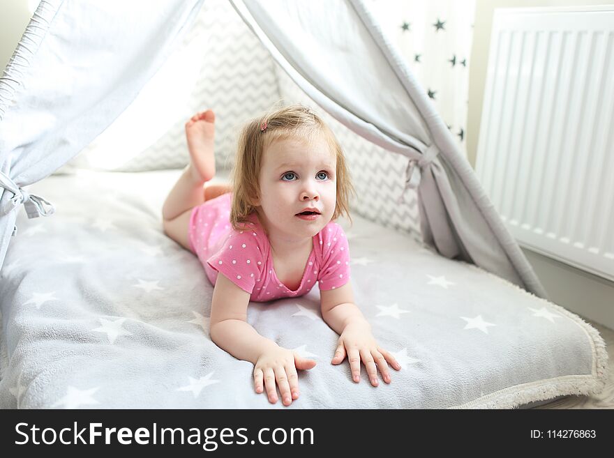 Happy little girl in wigwam tent bed at home. Happy little girl in wigwam tent bed at home