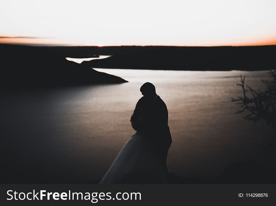 Wedding Couple, Groom, Bride Posing Near Sea On Sunset