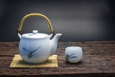 Hot Tea Pot On Bamboo Mat With Cup On Wooden Table Royalty Free Stock Photography