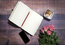 Top View Of Blank Sheet Of Notebook And Red And Pink Roses Flowers On Rustic Brown Wooden Table. Copy Space. Stock Photo