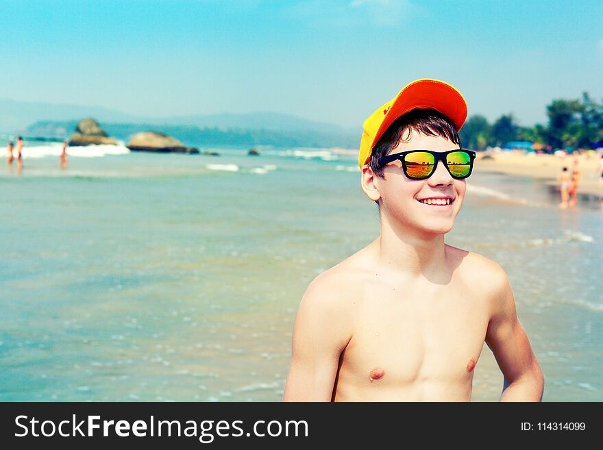 Portrait of positive joyful guy in colorful mirror sunglasses. Summertime concept. Portrait of positive joyful guy in colorful mirror sunglasses. Summertime concept