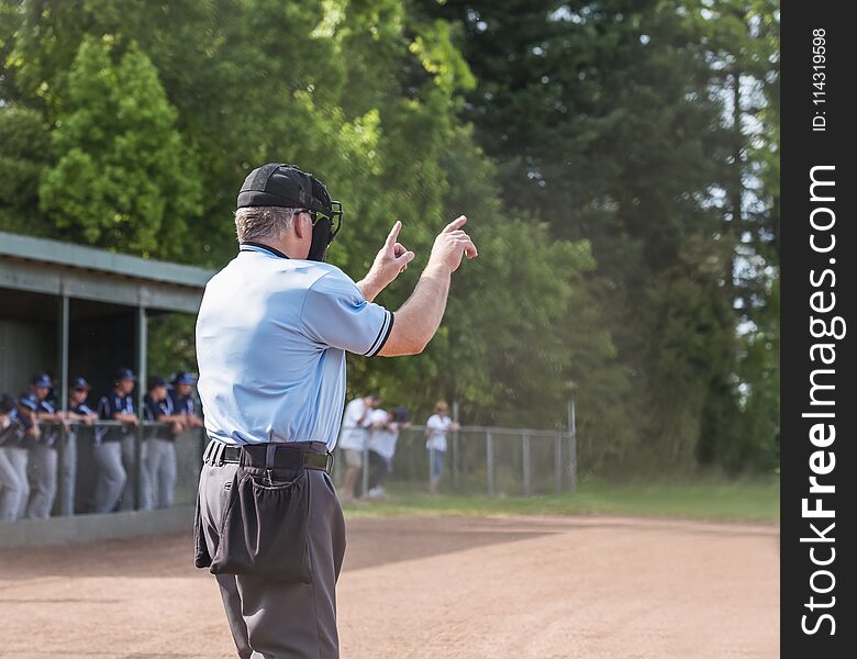 Umpire calls one ball, one strike , players in dugout in background