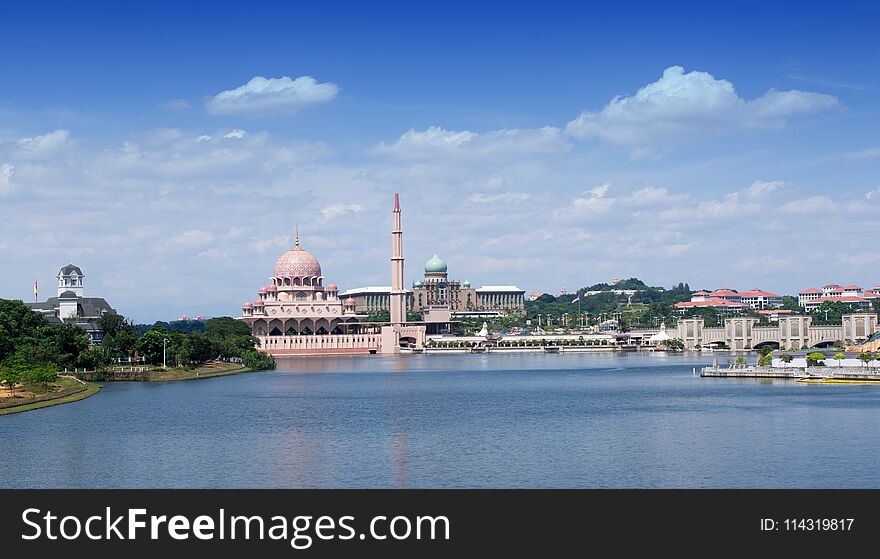 Landscape view of Putra mosque and office building of the prime minister at Putrajaya, Malaysia during morning. Landscape view building with lake, sky white cloud nature composition.