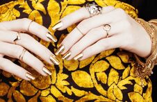 Woman Hands With Golden Manicure Lot Of Jewelry On Fancy Dress C Royalty Free Stock Photography