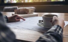 An Architect Working On An Architecture Model With Shop Drawing Paper While Drinking Coffee Stock Images An Architect Working On An Architecture Model With Shop Drawing Paper While Drinking Coffee Stock Images