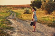 Young Woman On Country Road With Suitcase Royalty Free Stock Photos