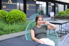 Female Person Resting At Street Cafe And Sitting Near Green Plant. Royalty Free Stock Image
