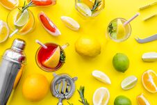 Mix Exotic Fruit Cocktail With Alcohol. Shaker And Strainer Near Citrus Fruits And Glass With Cocktail On Yellow Royalty Free Stock Image