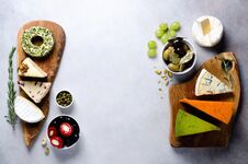 Assortment Of Hard, Semi-soft And Soft Cheeses With Olives, Grissini Bread Sticks, Capers, Grape, On Grey Concrete Stock Images Assortment Of Hard, Semi-soft And Soft Cheeses With Olives, Grissini Bread Sticks, Capers, Grape, On Grey Concrete Stock Images