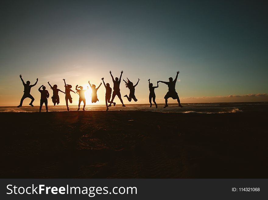 Silhouette Photography Of Group Of People Jumping During Golden Time