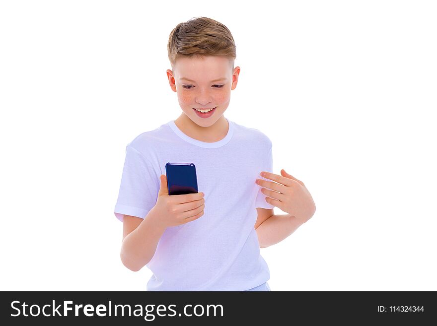 Close-up portrait.A small boy of school age uses a mobile phone. The concept of digital technology, communication between people. Isolated on white background. Close-up portrait.A small boy of school age uses a mobile phone. The concept of digital technology, communication between people. Isolated on white background.