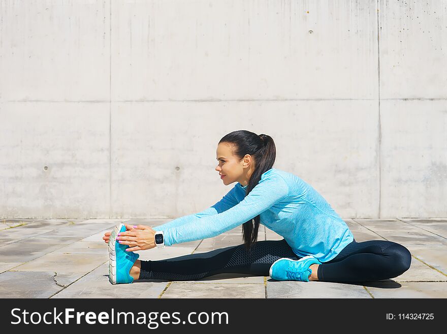 Young, fit and sporty girl stretching in the street. Fitness, sport, urban jogging and healthy lifestyle concept. Young, fit and sporty girl stretching in the street. Fitness, sport, urban jogging and healthy lifestyle concept.