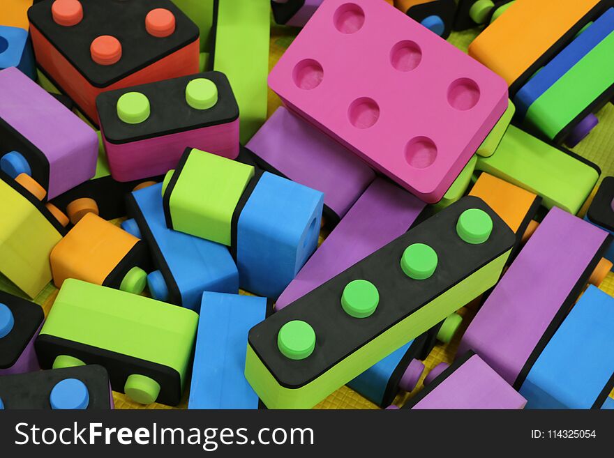 Children`s constructor. Big pile plastic toy blocks. Background of bright plastic big building blocks. Children`s multicolor soft designer. Puzzle. Popular toys.