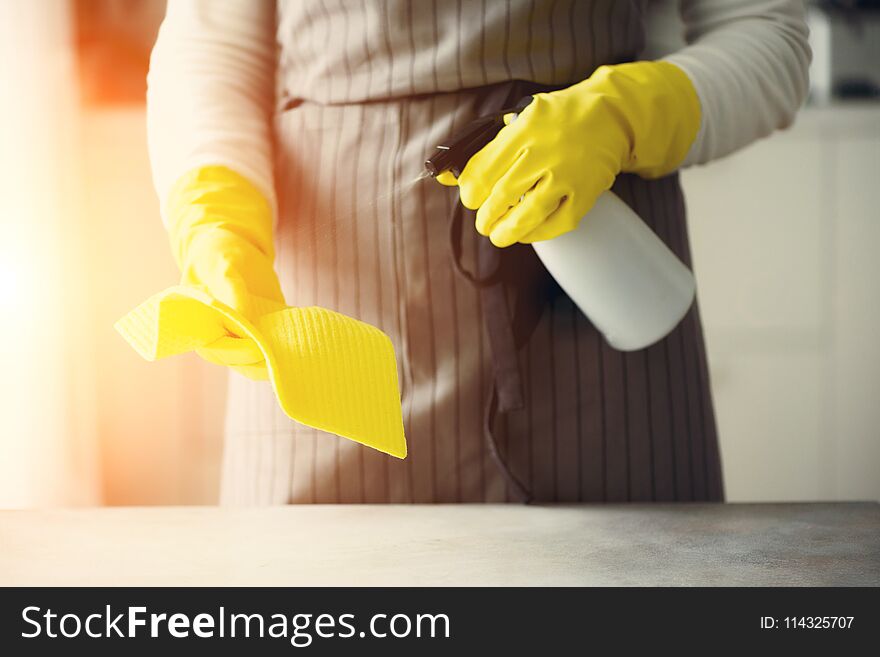 Woman in yellow rubber protective gloves wiping dust and dirty. Cleaning concept, banner, copy space.