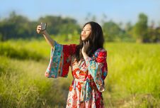 Young Beautiful And Happy Asian Chinese Tourist Woman On Her 20s With Colorful Dress Taking Selfie Pic With Mobile Phone Camera On Stock Photo