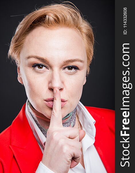 Portrait of attractive business showing sush gesture on black background