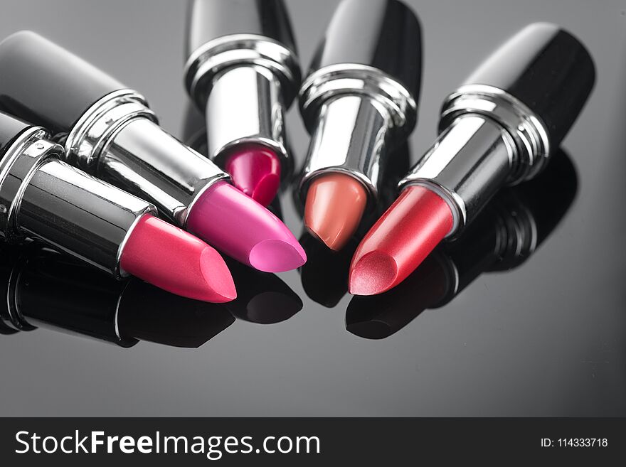 Lipstick. Professional makeup and beauty. Lipstick tints palette closeup. Colorful lipsticks over black background