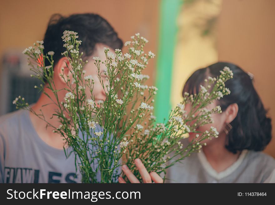 Photo Of Man And Woman Behind The Flowers