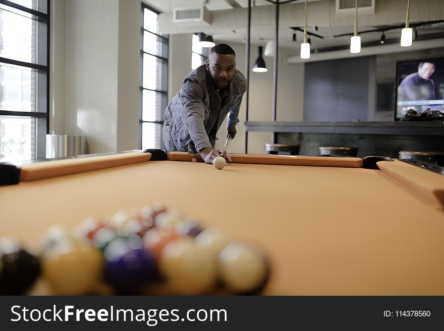 Male Holding Cue Stick Ready to Hit the Ball