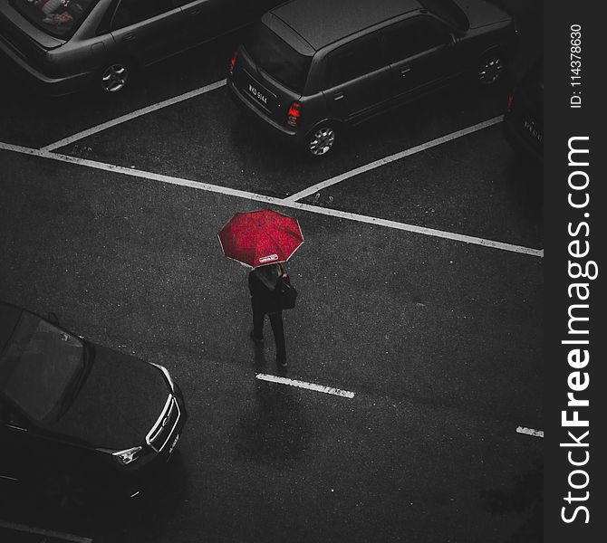 Person Holding Red Umbrella Walking on Street