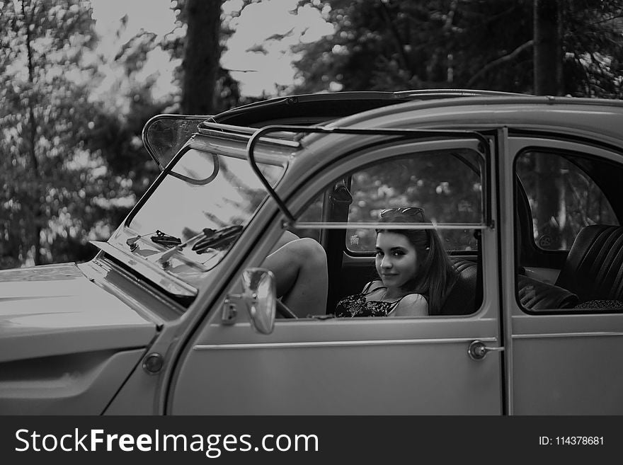 Grayscale Photo Of Woman Inside Classic Car