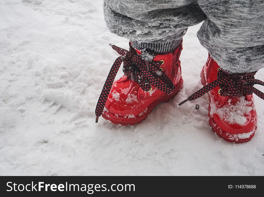 Toddler Wearing Red Shoes Standing On Snow