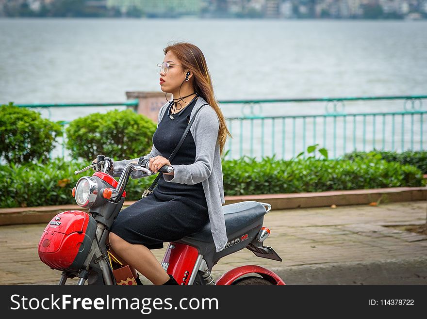 Woman Riding Red Motor Scooter