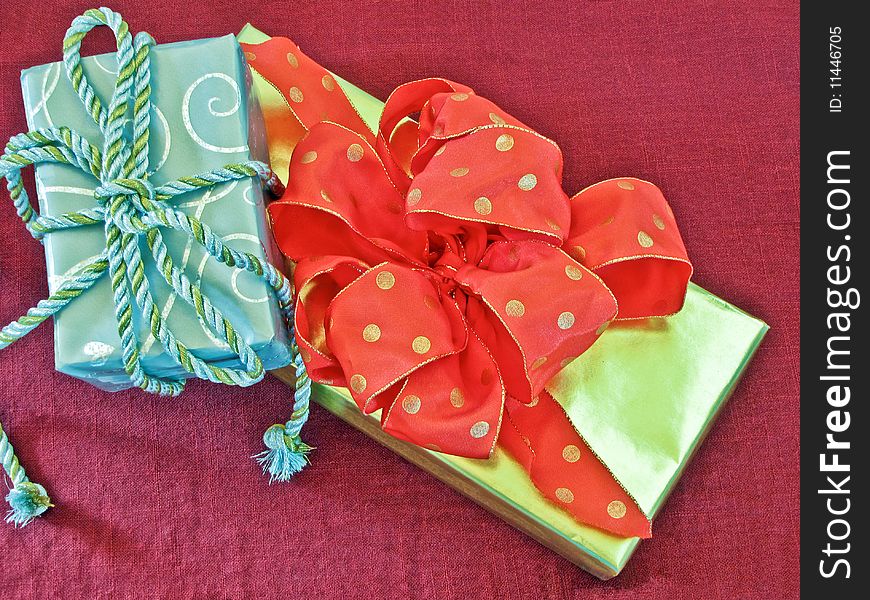 Silver and gold gifts on a red background with ribbons and bows. Silver and gold gifts on a red background with ribbons and bows