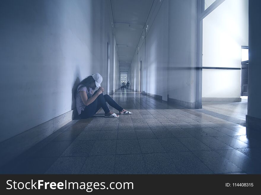 Lonely woman sitting in the hallway with sad expression