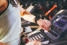 Close-up Of A Young Caucasian Woman`s Hand In The Gym Uses A Sports Watch, A Black Pulse Wrist On The Back Of A Treadmill In A Sp Royalty Free Stock Images