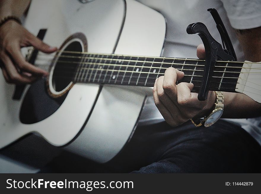 Man Holding a White Dreadnought Acoustic Guitar