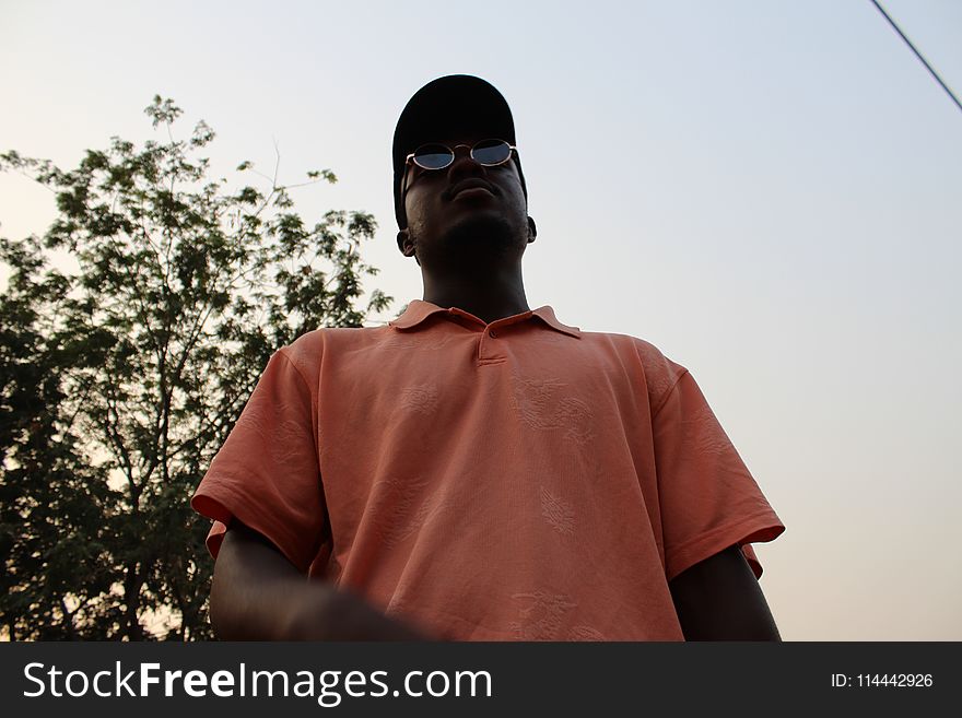 Man In Pink Polo Shirt Standing Near On Green Tree