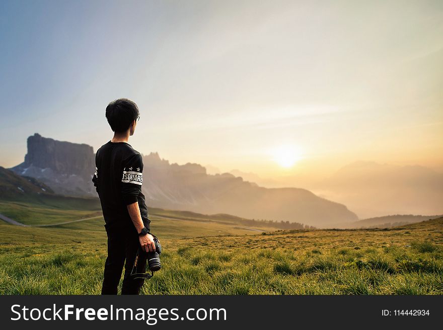 Sepia Photography Of Man Wearing Black Sweatshirt Holding Camera