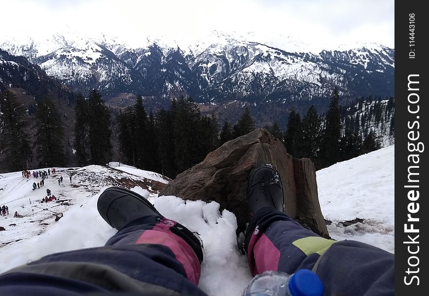 Person Wearing Black Boots At Snowy Mountain
