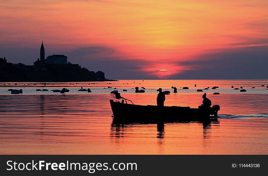 Silhouette Of Two Men On Boat Under Orange Sky