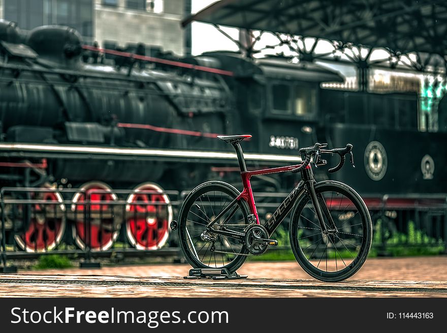 Black And Red Road Bike Near Black Train